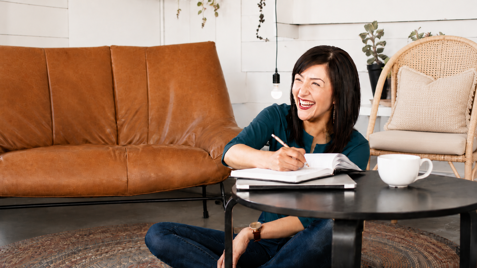 Amy, founder of Socialize Your Biz, laughing while writing in a notebook
